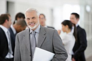 Homme actif souriant avec un ordinateur portable sous le bras